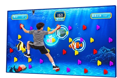 Child climbing the Augmented Climbing Wall beside an underwater interactive game display